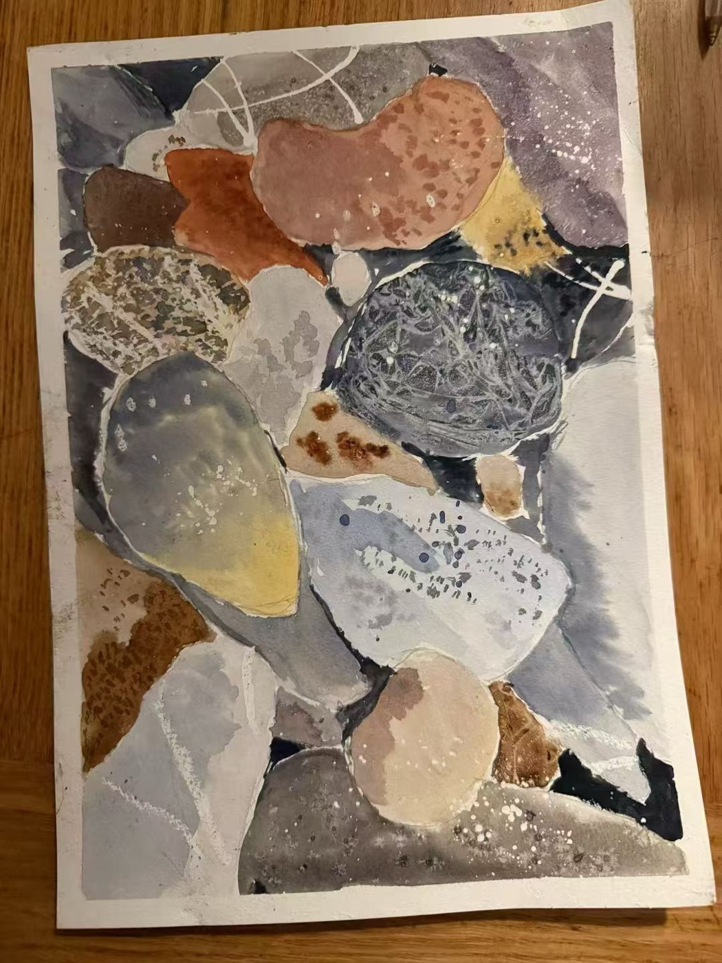 Watercolour study of river stones in slate and ochre